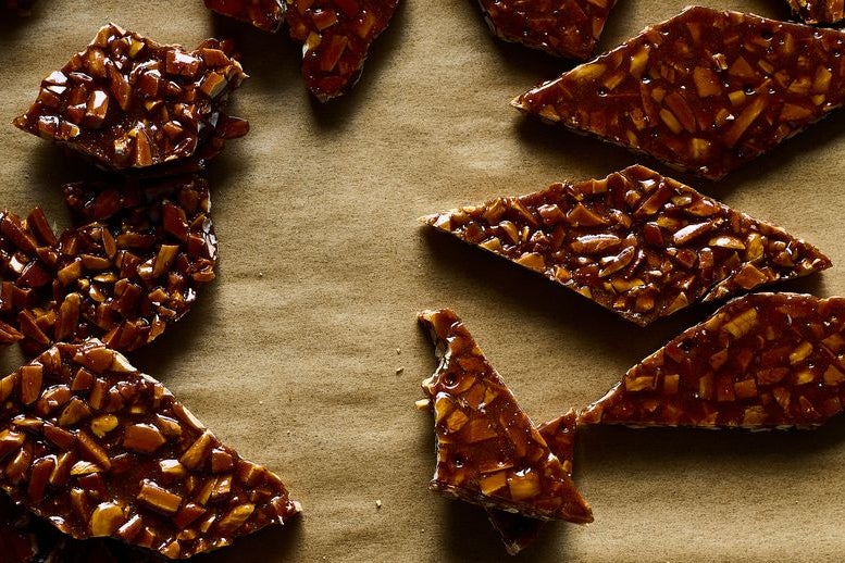 Pieces of almond brittle on parchment paper.